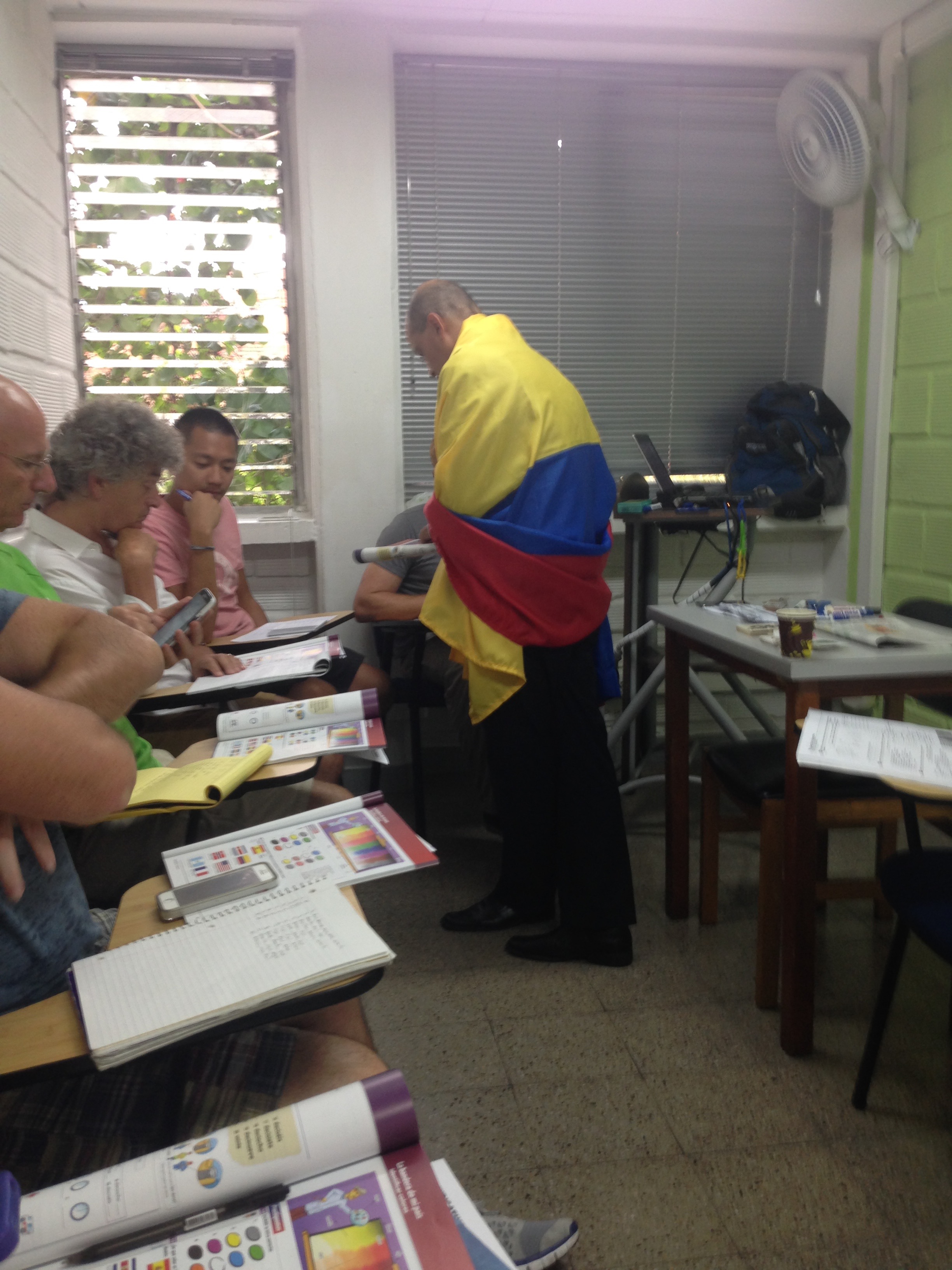 11 Honest Reasons To Learn Spanish in Medellin, Colombia • IMG 7696 Crazy Colombian teacher draped in Colombian flag while locals study Spanish in Medellin