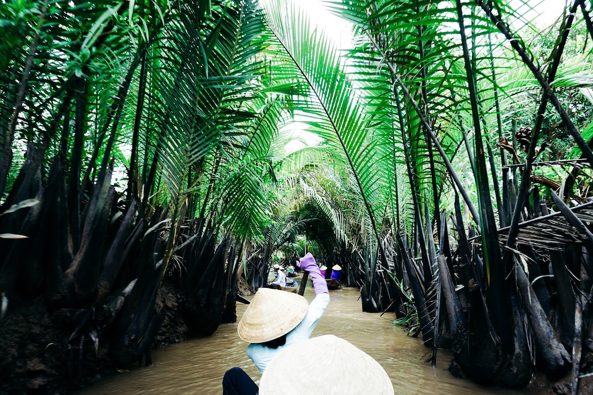 Best Vietnam Motorbike Routes: 5 Suggested Itineraries • Mekong Delta Local lady rowing in the Mekong Delta, Vietnam.
