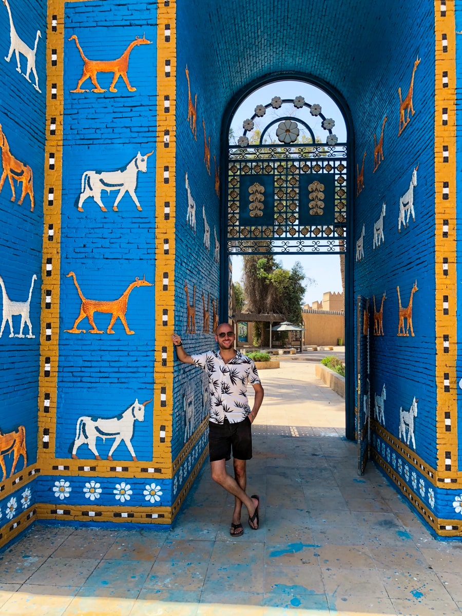 A male tourist poses in sunglasses at The Gates of Babylon entrance 