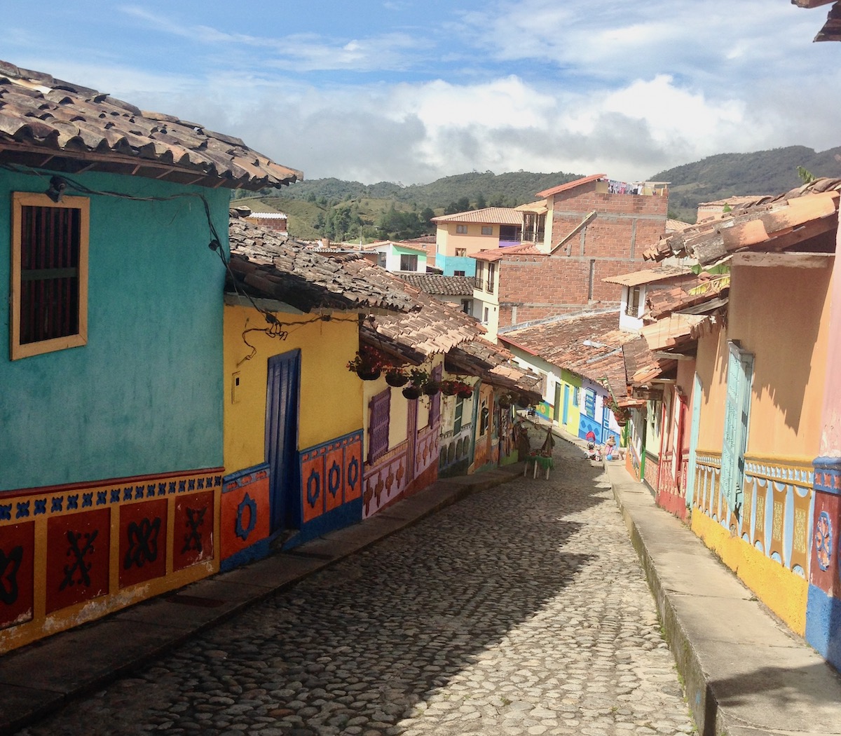 Colourful houses on a cobblestone path on a sunny day in Guatape, a popular day trip from Medellin in Colombia 