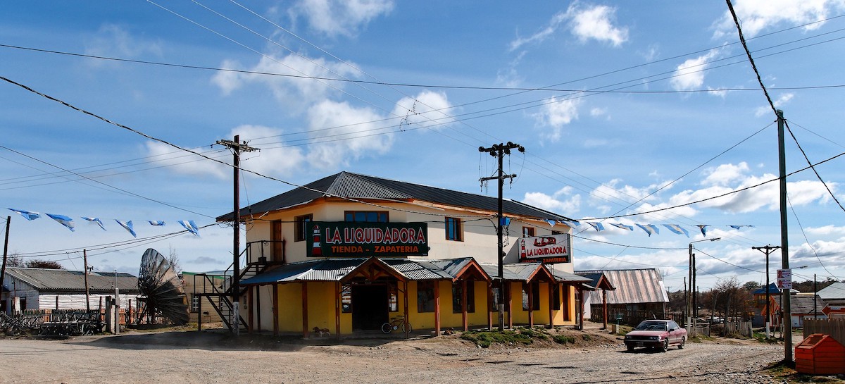 A yellow and white building stands alongside multiple Argentina flags