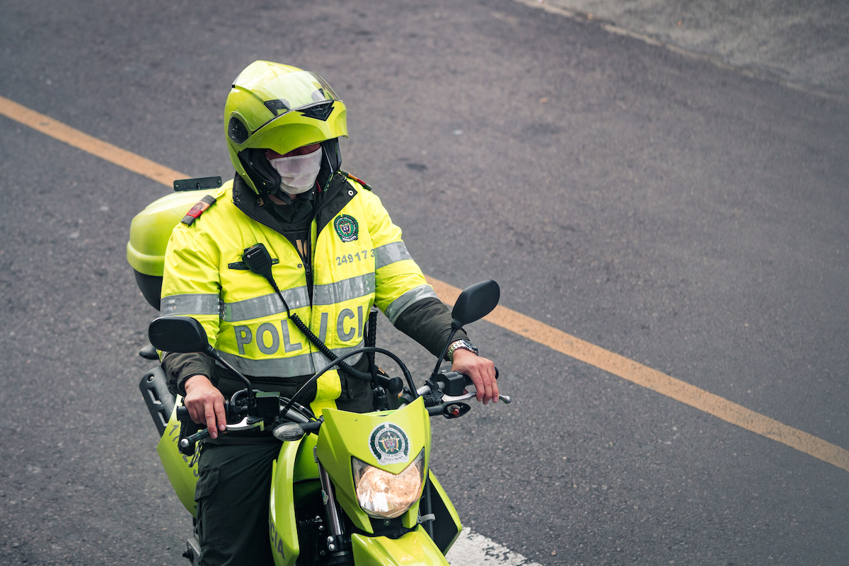 7 Things To Know Before Living in Medellin, Colombia • colombian policeman A Colombian policeman on a motorbike wearing a mask.
