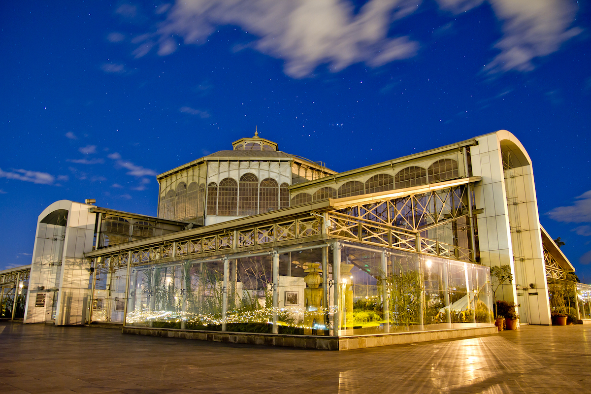 A large clear glass building lit up at night in Quito, Ecuador.