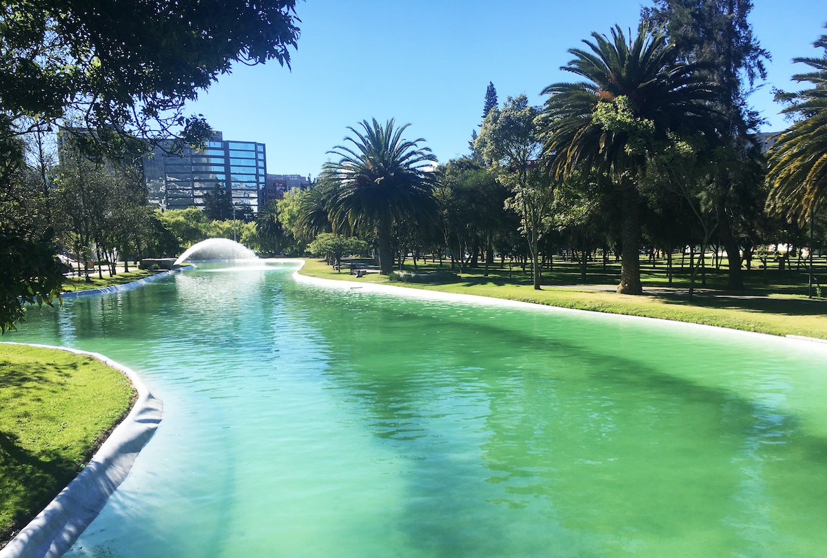 A lake runs through a green park in Quito, Ecuador.