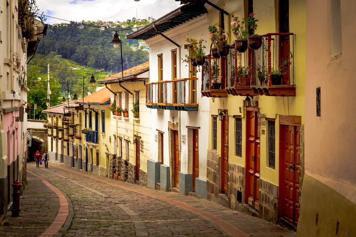A cobble-stoned street with yellow buildings in Quito, Ecuador.