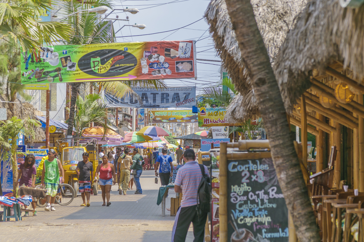 The picturesque urban scene at the street with lots of stores in Montanita, the most famous watering place in Ecuador