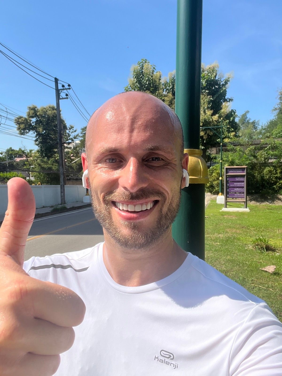 Man in white t-shirt puts the thumbs up as he begins to run 5k every day